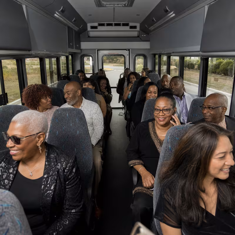 Group boarding a white charter bus for Private Event Transportation transportation in New Orleans