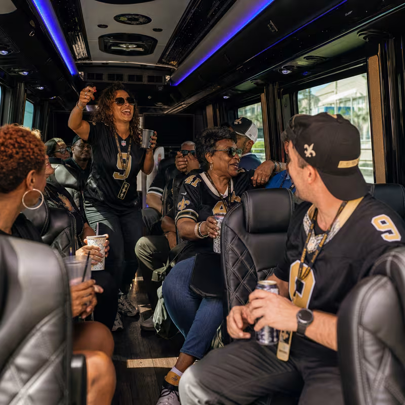 Group boarding a white charter bus for Sporting Event Transportation transportation in New Orleans